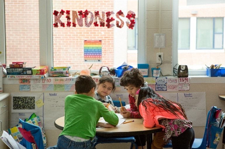 four students sitting around a table