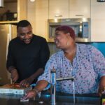 Black man and Black woman at a kitchen sink