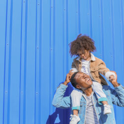 Man looking up at child on his shoulders