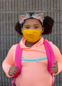 girl with backpack wearing a fabric mask