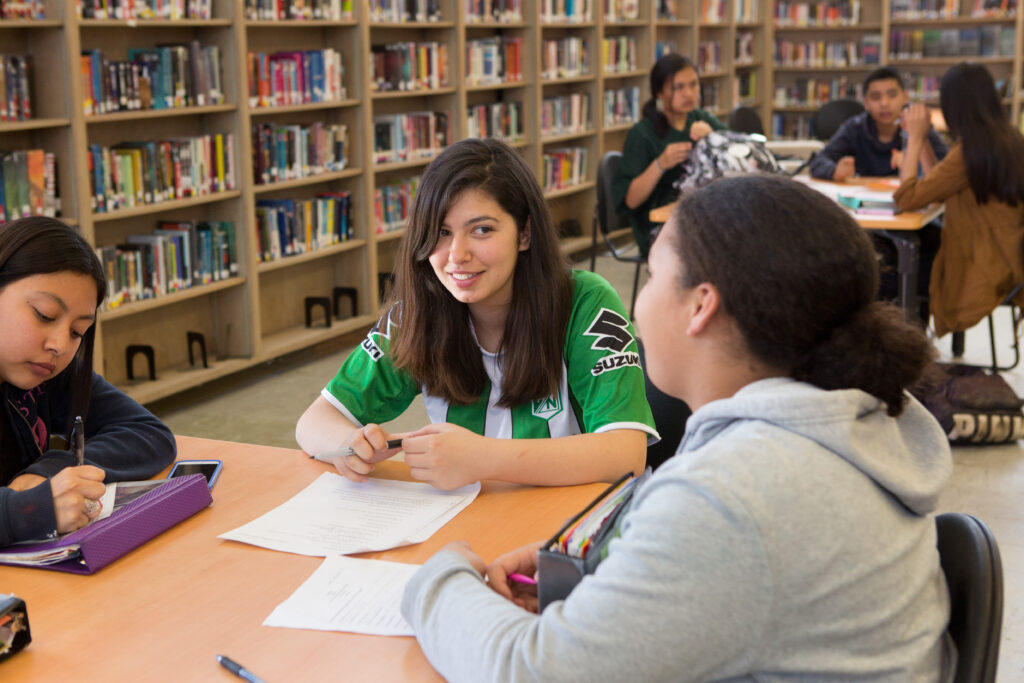 Students sitting at a table in the school library