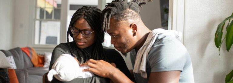 A person and person holding a baby Description automatically generated