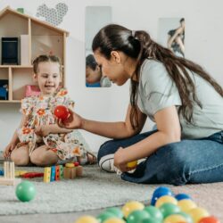 woman on the floor playing with a child