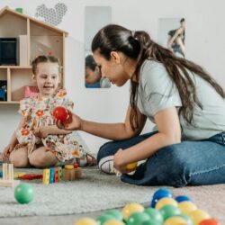 woman on the floor playing with a child
