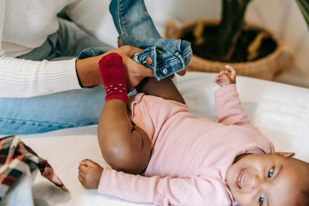 Caregiver dresses a baby lying on their back