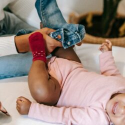 Caregiver dresses a baby lying on their back